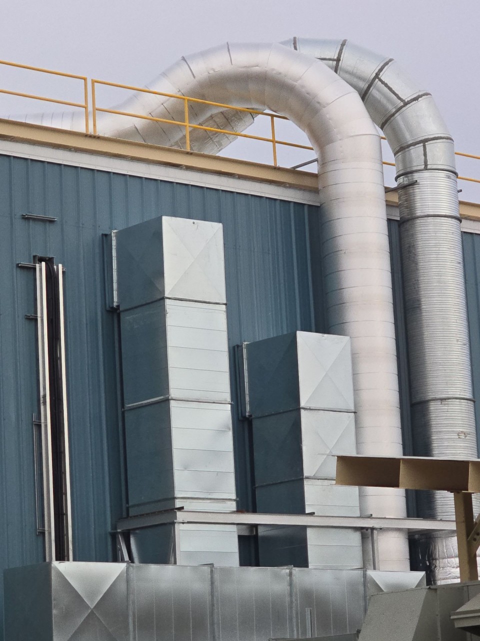 Duct turning over the roof parapet beside the support towers