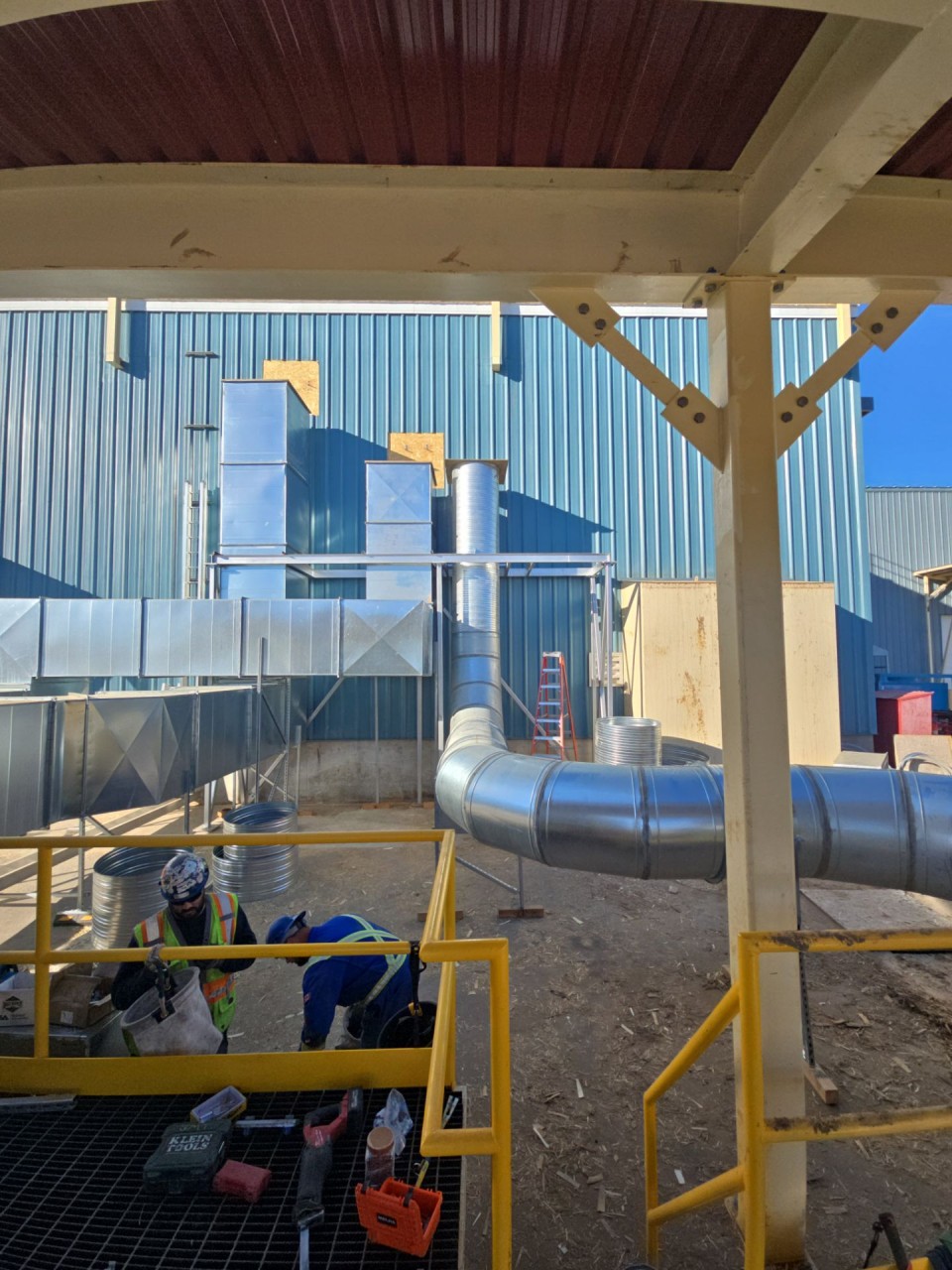 Sheet metal crew working under the installed duct